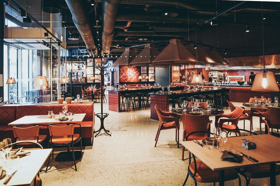 Salon de restaurante con mesas listas para recibir clientes